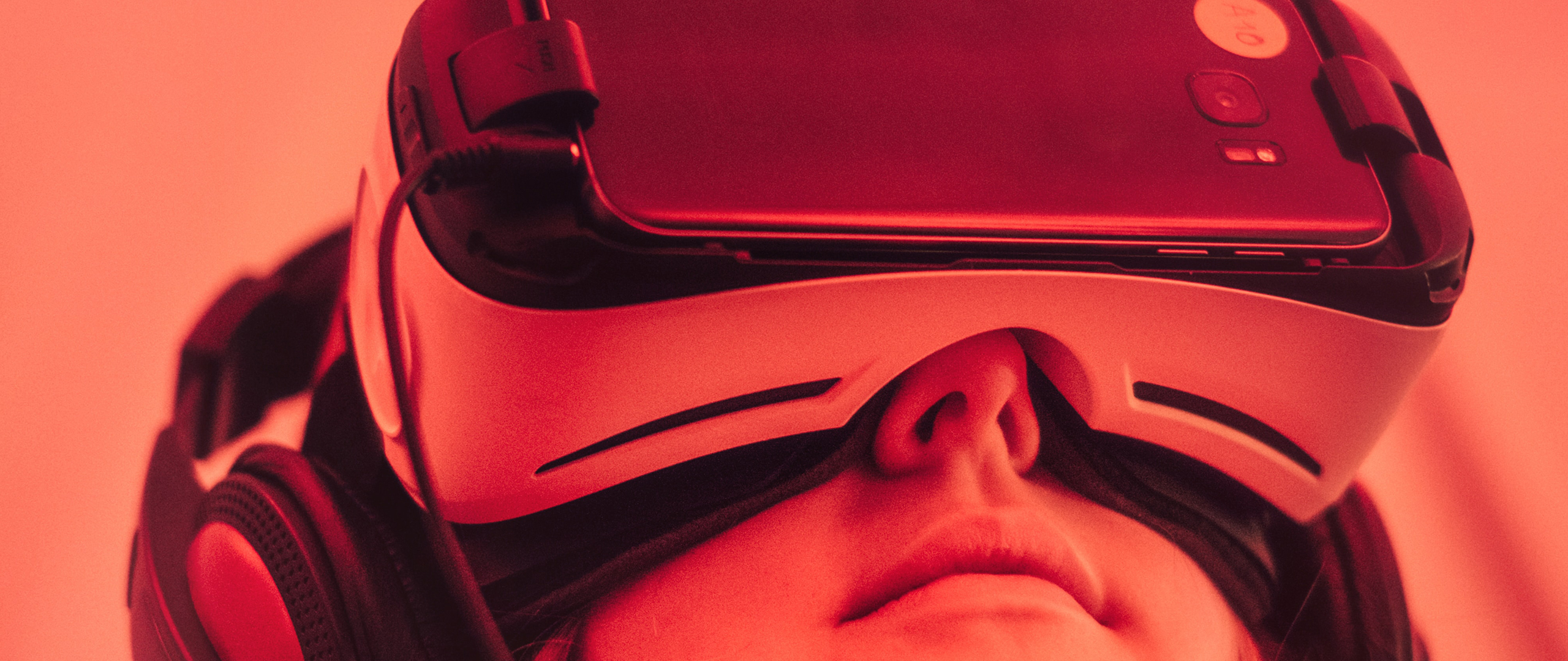 Een vrouw die een VR bril draagt die gekoppeld is aan een mobiele telefoon