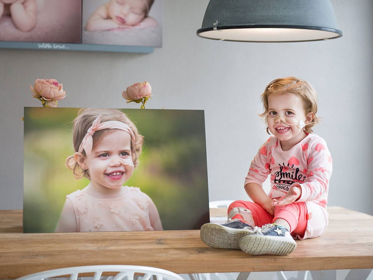 Een tafel met daarop een aluminium foto product en een kind